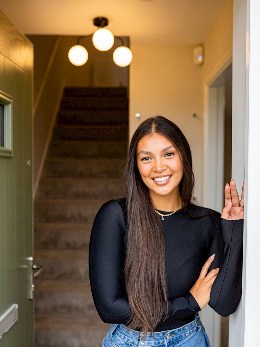 Young solo homeowner stood in front doorway