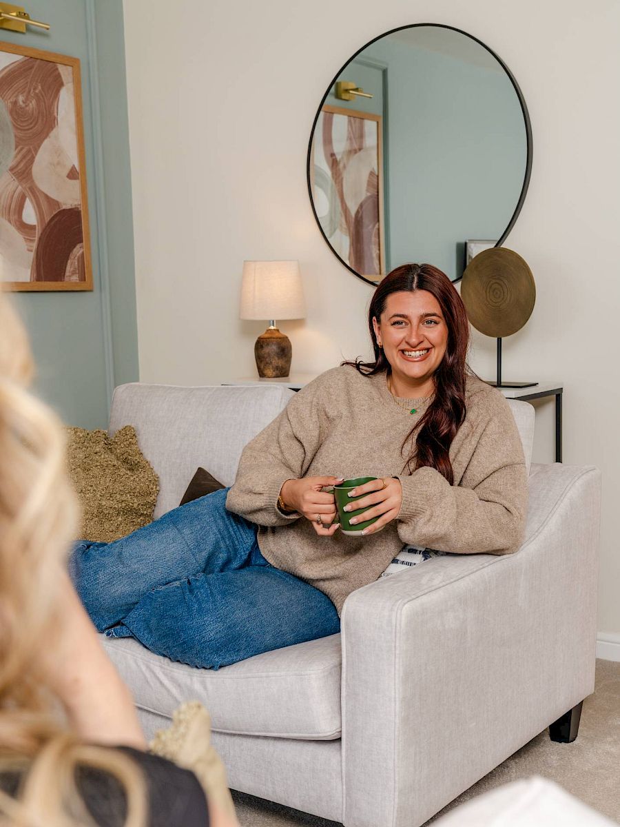 Woman sat on sofa smiling