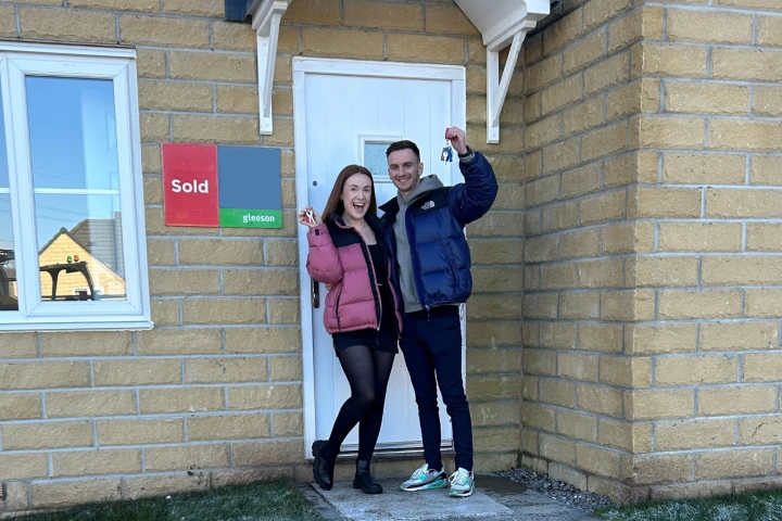 Customers smiling in front of their home