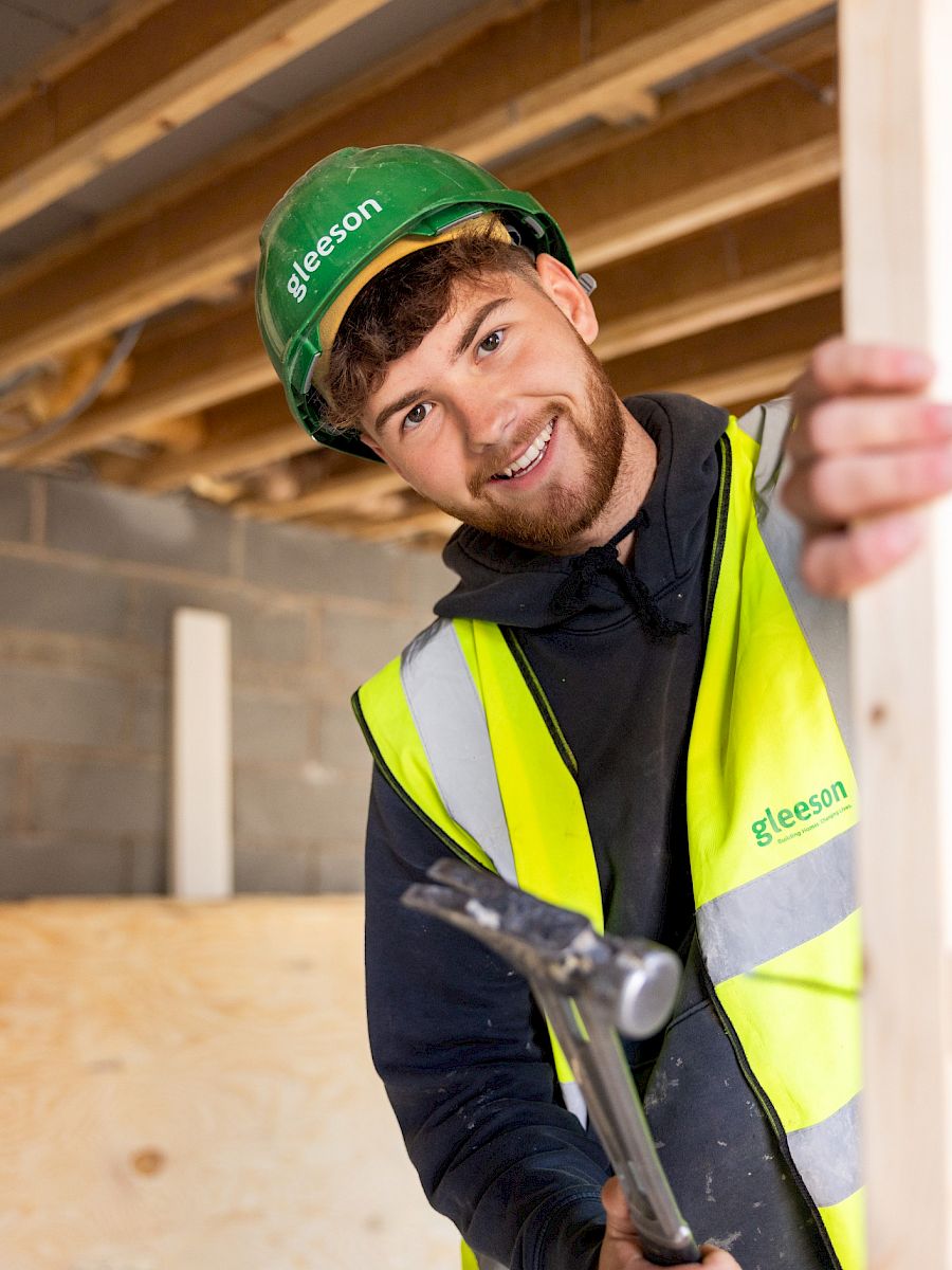 Worker smiling in front of site in PPE.