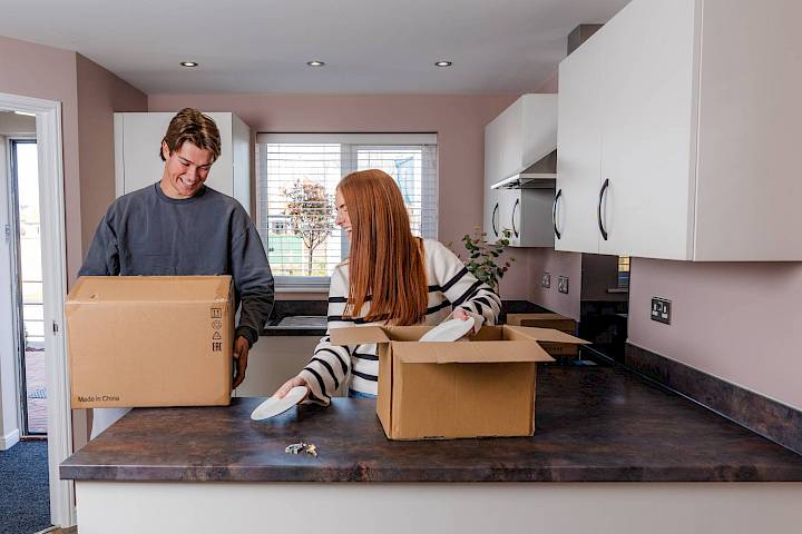 Young couple unpacking boxes in new home