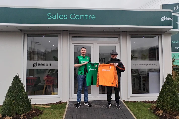 Barlick Wanderers managers standing outside sales centre with new kit sponsorship