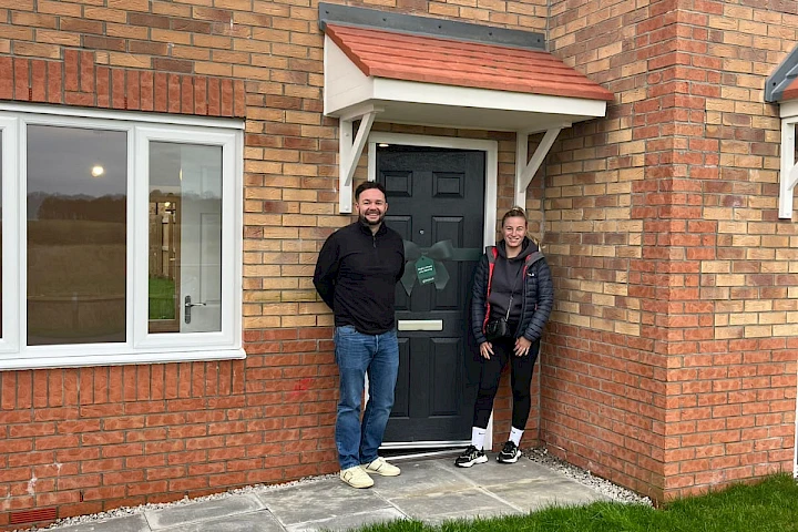 Happy couple pictured outside their new home