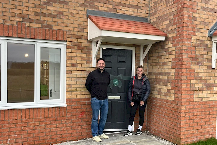 Happy couple pictured outside their new home