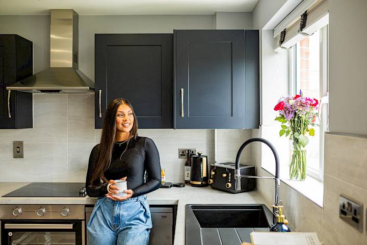 Young female sole home owner standing in the kitchen