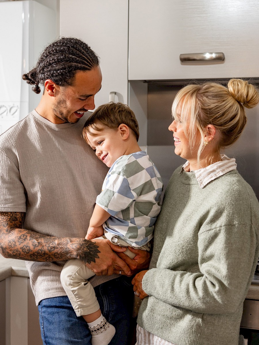 Happy family stood in kitchen smiling