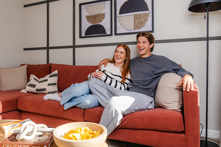 Young female and male sitting on a sofa in their living room