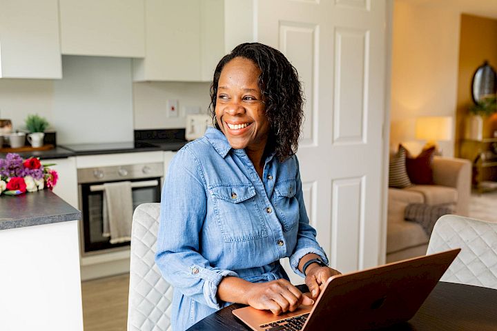 Woman sat with laptop smiling