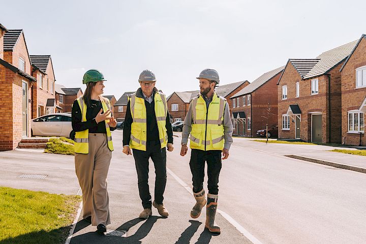 Female and site managers walking through a new build housing estate