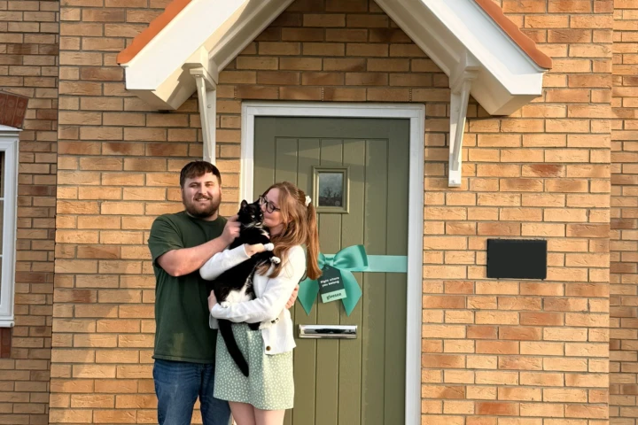 Couple at the front of their home with Cat