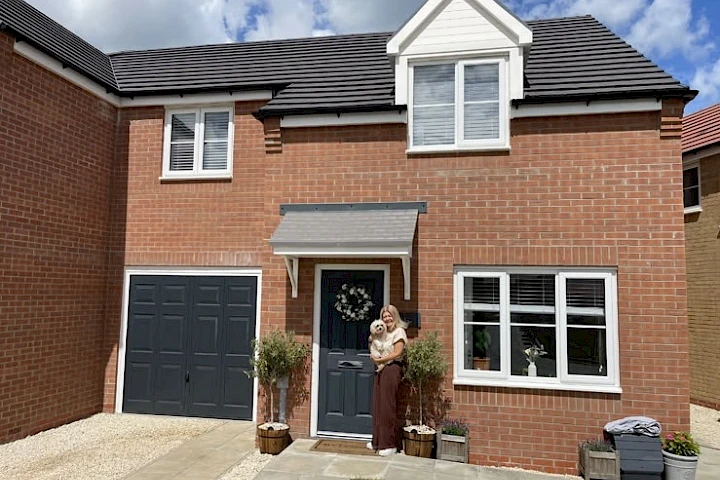 Customer at the front of her home with dog