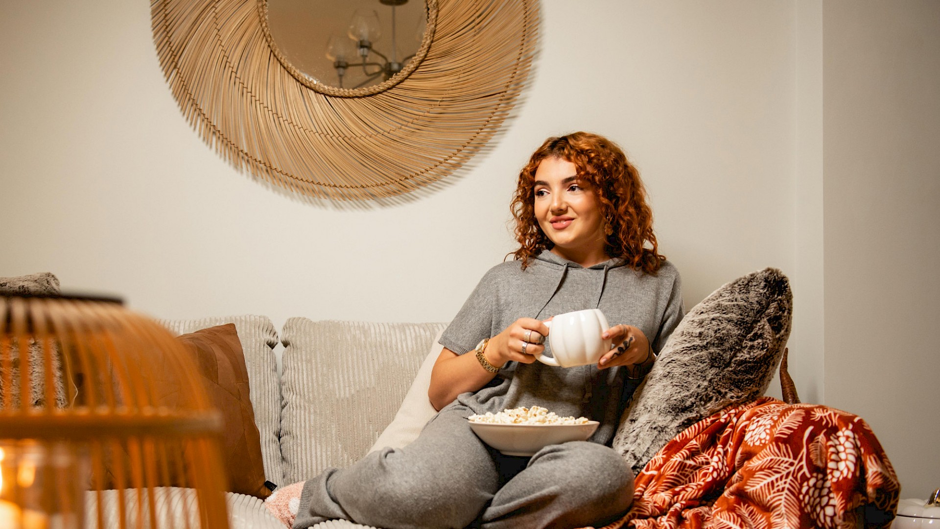 Happy lady enjoying a cup of coffee in her livingroom