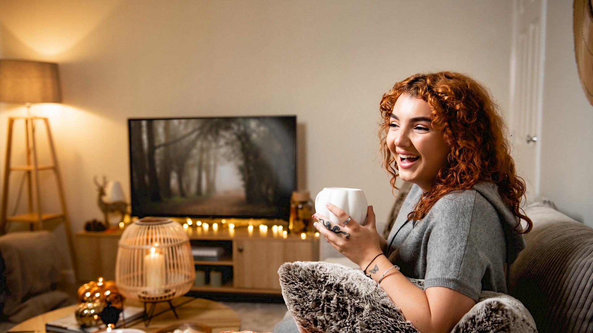 Happy lady enjoying a cup of coffee in her livingroom
