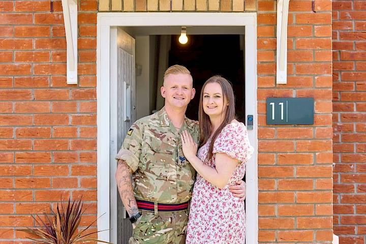 Happy couple standing in doorway (one in Armed Forces dress)