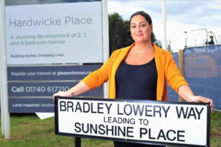 Female standing in front of housing development sign
